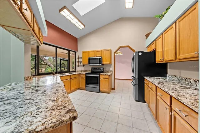 a kitchen with stainless steel appliances granite countertop a stove a sink and a microwave