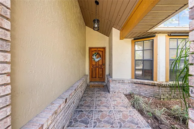an empty room with wooden floor cabinet and windows