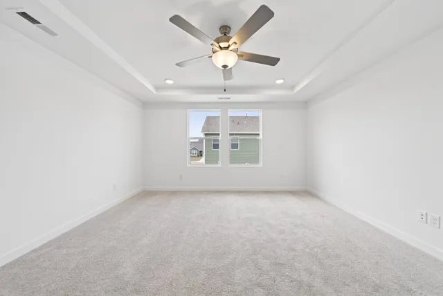 an empty room with a ceiling fan and window