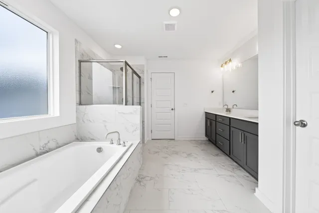 a bathroom with a tub a sink and a mirror