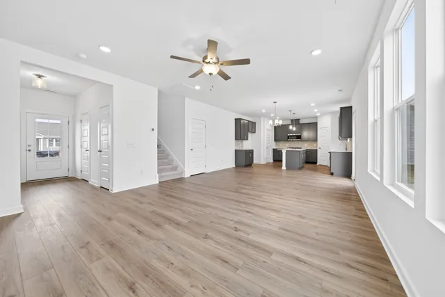 a view of a livingroom with wooden floor and a ceiling fan