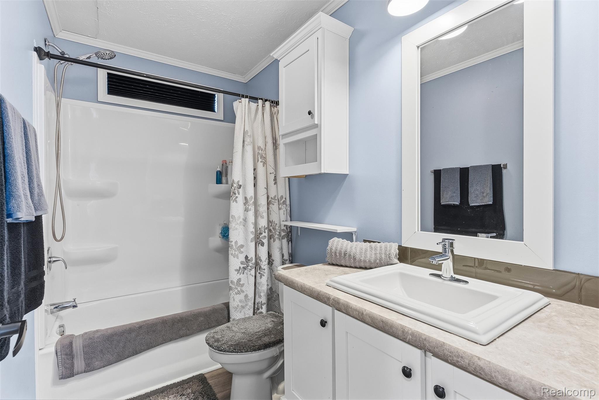 6450 Prince Boulevard Fenton, MI 48430 - Photo 21 of 31 Bathroom featuring a white vanity with integrated sink, chrome faucet, and framed mirror