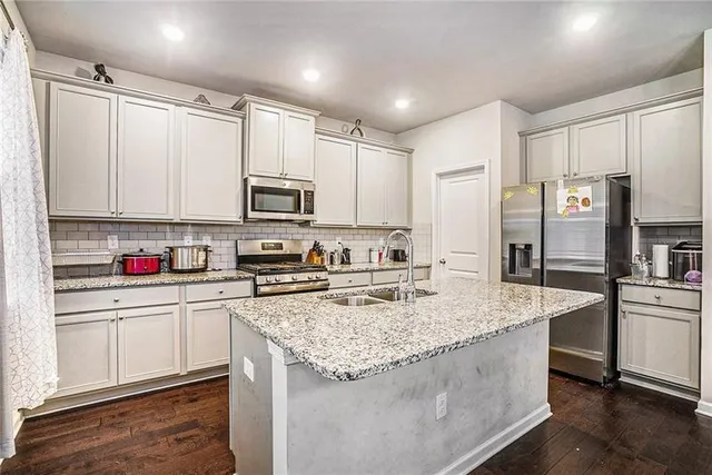 a kitchen with stainless steel appliances granite countertop a sink refrigerator and microwave