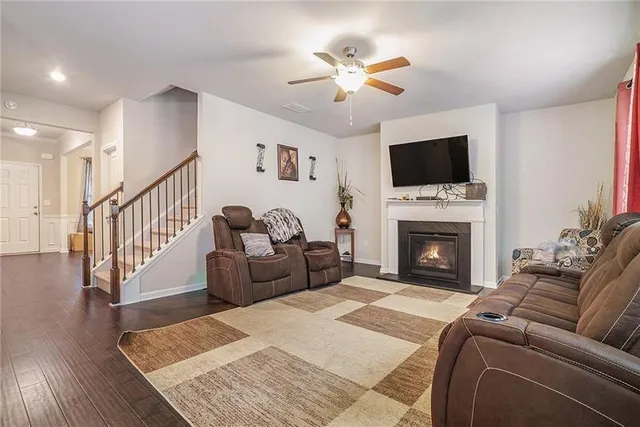 a living room with furniture a flat screen tv and a fireplace