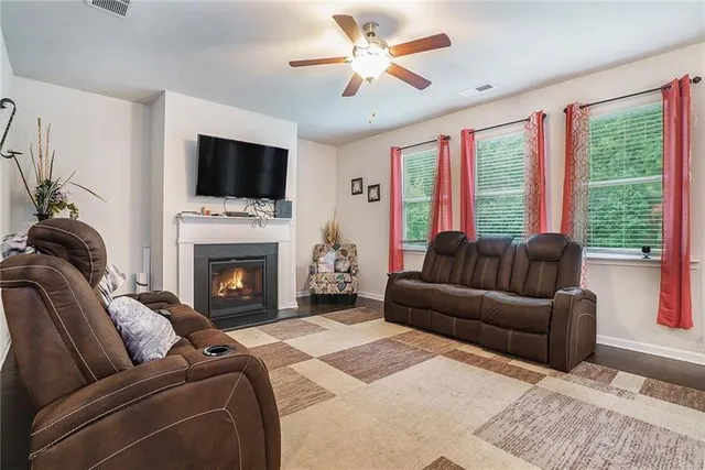 a living room with furniture a flat screen tv and a fireplace