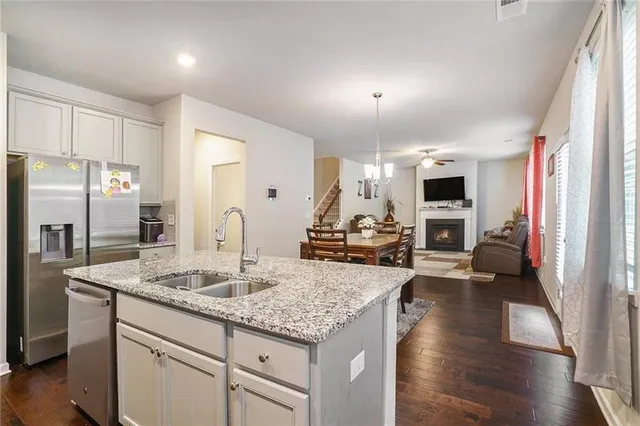 a kitchen with granite countertop kitchen island stainless steel appliances a sink stove and refrigerator