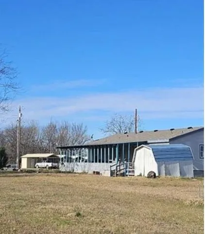 a view of a big house with a big yard and large tree