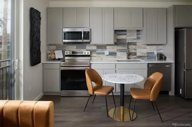 a kitchen with stainless steel appliances a stove a sink refrigerator and a microwave