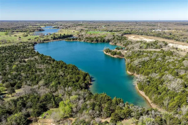 an aerial view of residential houses with outdoor space and lake view