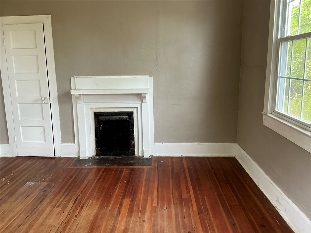 14 Ames Street Seneca, SC 29678 - Photo 8 of 16 This living area features a classic fireplace and gleaming hardwood floors, creating an inviting space.