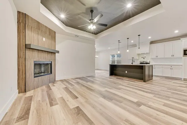 a large white kitchen with kitchen island a stove and a sink