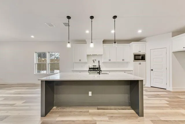 a kitchen with kitchen island a sink stainless steel appliances and cabinets