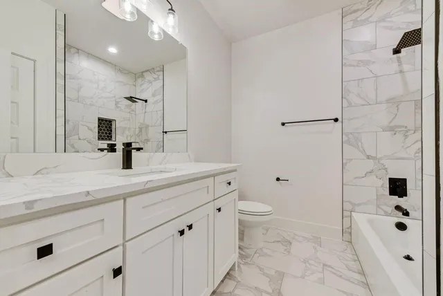 a bathroom with a double vanity sink toilet and shower