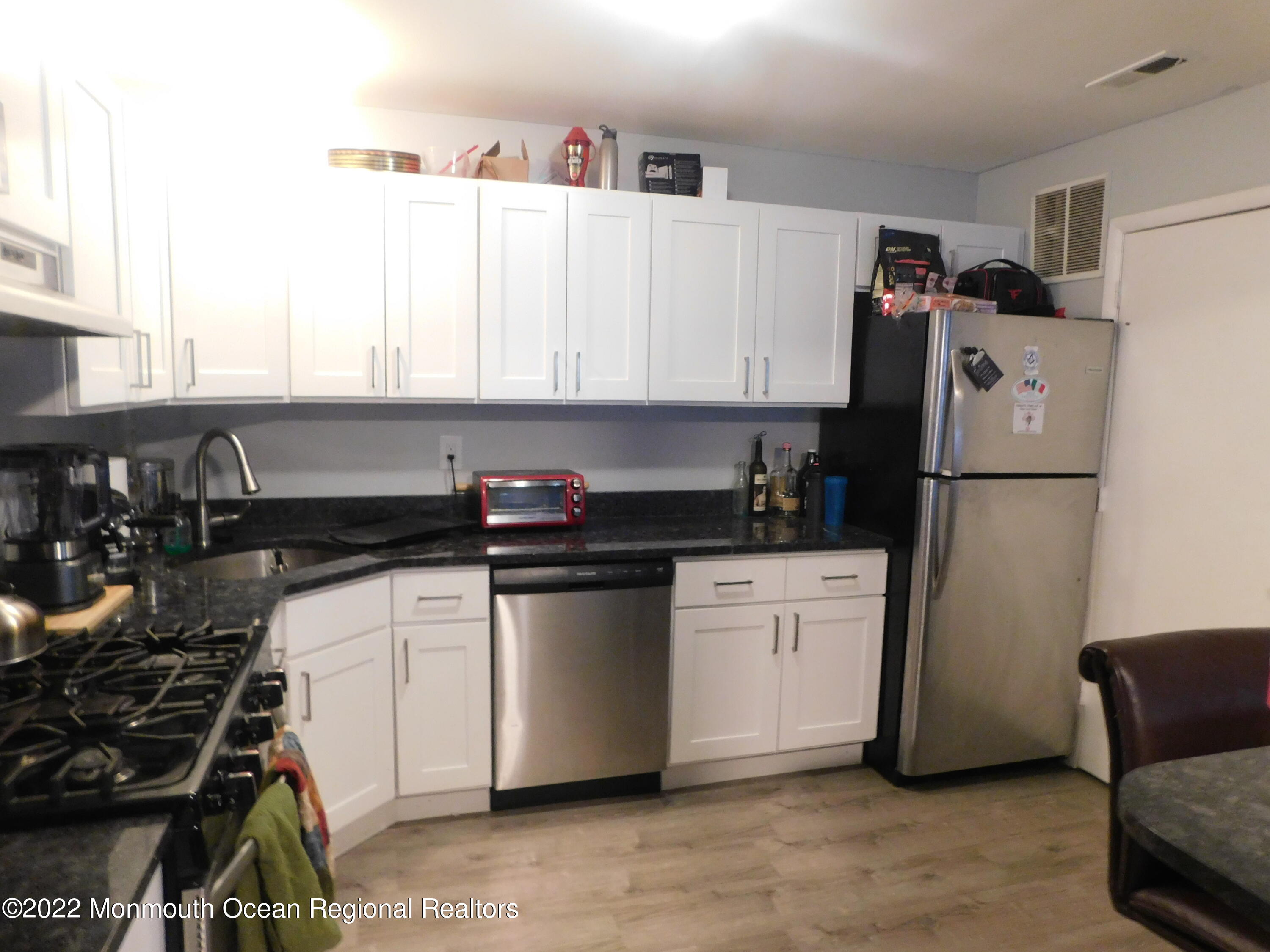 716 Zlotkin Circle, Unit 4 Freehold, NJ 07728 - Photo 2 of 10 a kitchen with granite countertop a refrigerator stove top oven and sink