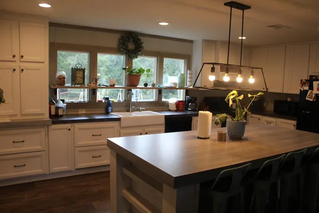 a kitchen with a table chairs and white cabinets