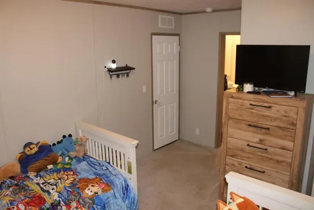 a bedroom with a bed and flat screen tv