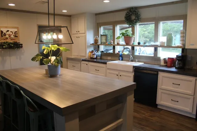 a kitchen with a sink a counter space dining table and wooden floor