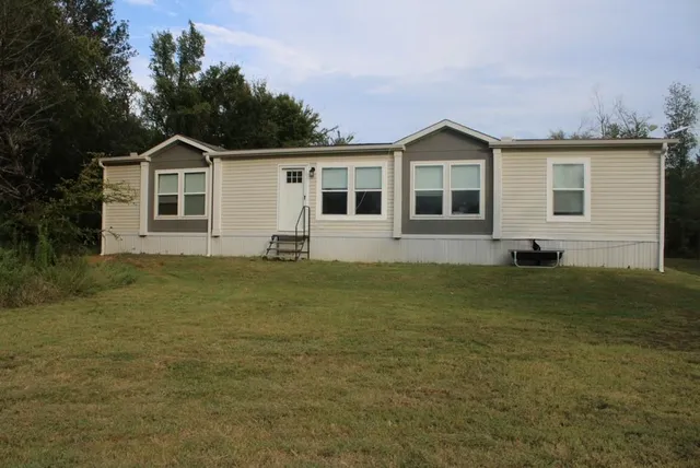 a front view of house with yard and green space