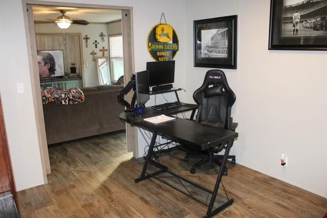a view of a workspace with furniture and wooden floor