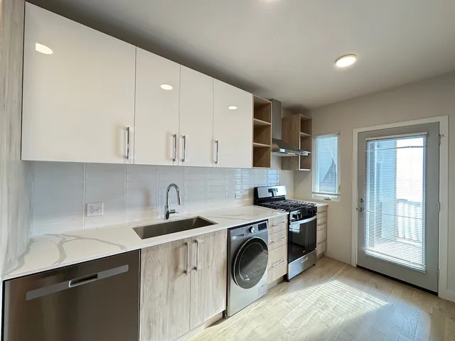 a kitchen with a sink a stove and cabinets
