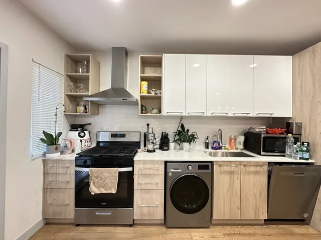 a kitchen with stainless steel appliances granite countertop a stove a sink and a refrigerator
