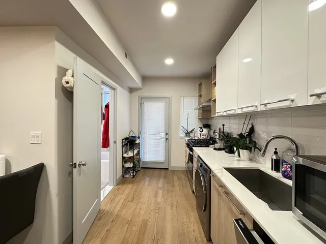 a kitchen with granite countertop a sink stove refrigerator and cabinets