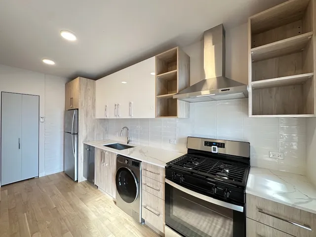 a kitchen with stainless steel appliances granite countertop a stove and a refrigerator