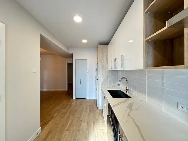 a kitchen with a sink and wooden floor