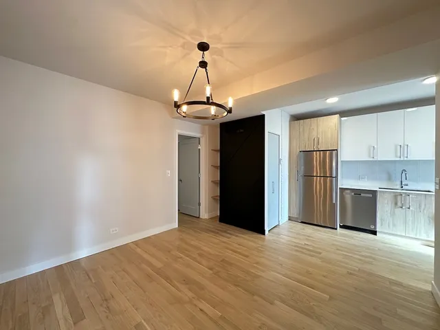 a view of a kitchen with a sink and refrigerator