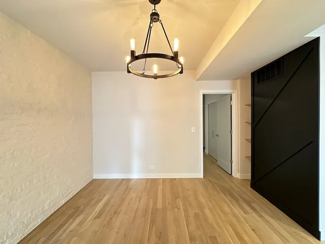 a view of a room with wooden floor and a window