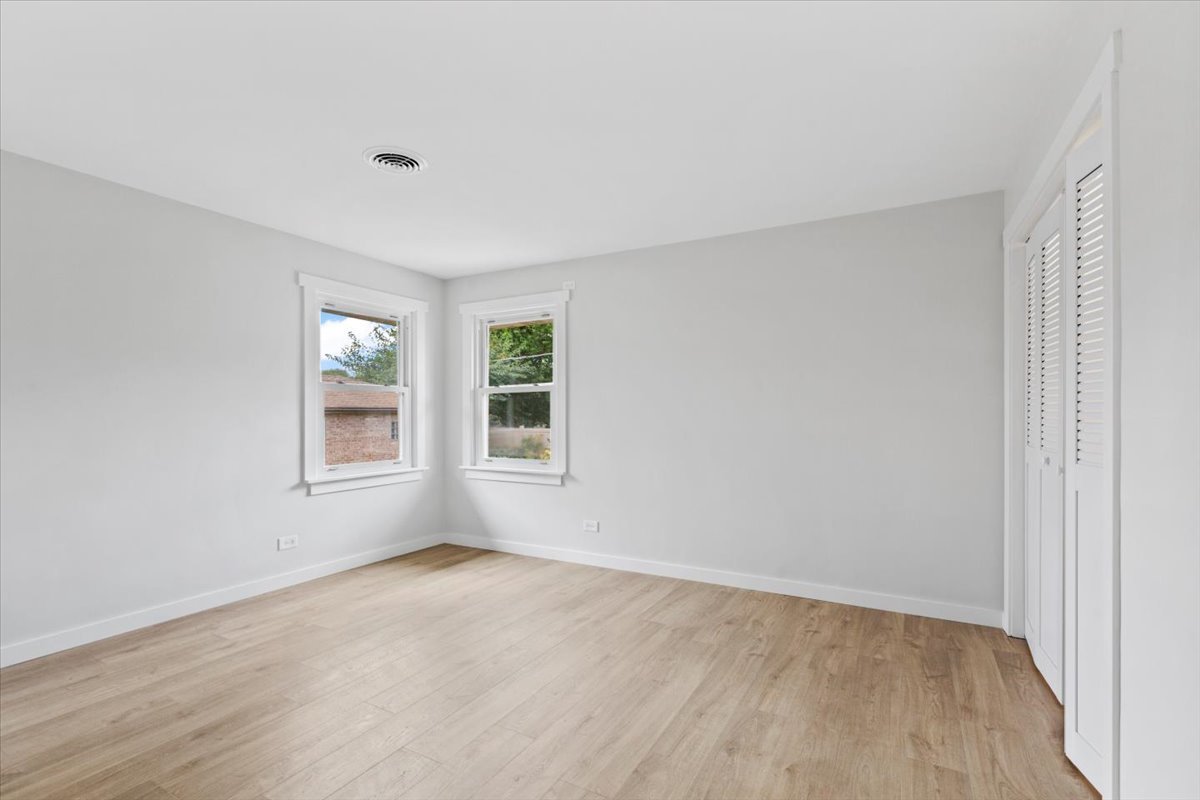 10206 South St Louis Avenue Evergreen Park, IL 60805 - Photo 16 of 33 an empty room with wooden floor and windows