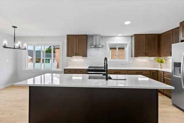 a kitchen with granite countertop a stove a sink and a refrigerator