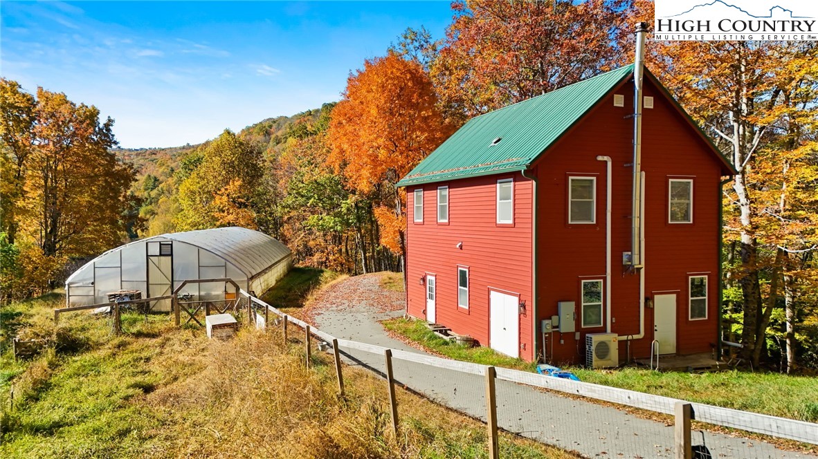 3242 Howard's Creek Road Boone, NC 28607 - Photo 2 of 33 a front view of house with yard and trees in the background