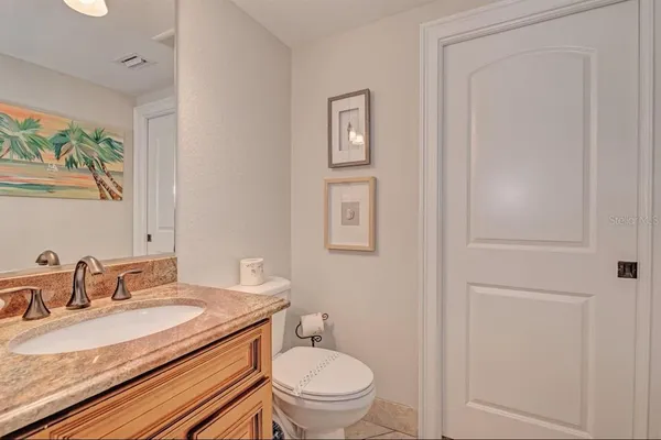 a bathroom with a granite countertop sink toilet and a mirror