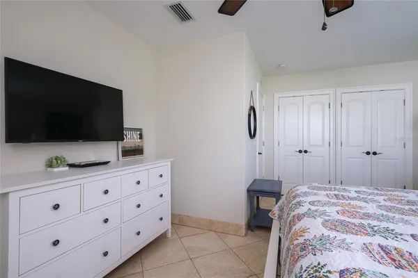 a bedroom with a bed and a flat tv screen on the dresser