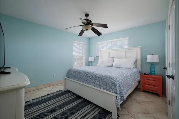 a bedroom with a bed and a chandelier fan