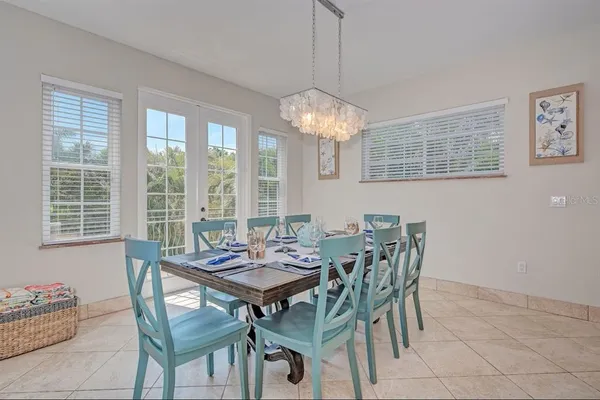 a dining room with furniture a chandelier and wooden floor