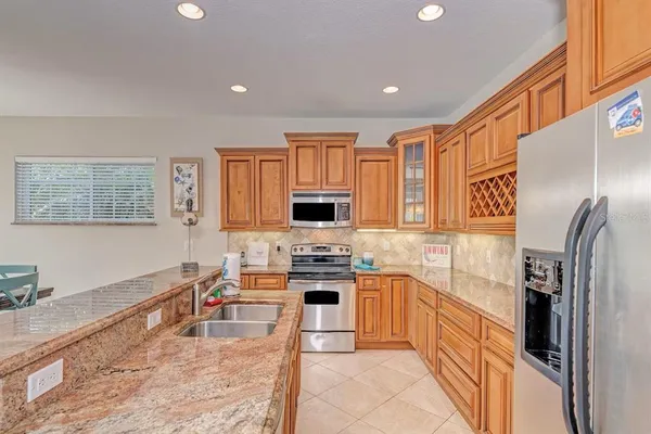 a kitchen with stainless steel appliances granite countertop a refrigerator stove top oven and sink