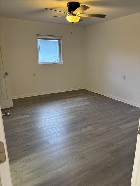 9030 Blind Pass Road, Unit C7 St. Petersburg, FL 33706 - Photo 8 of 16 a view of an empty room with wooden floor