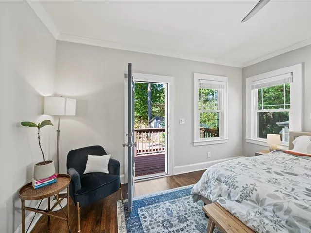 a bedroom with a bed and a window with chair