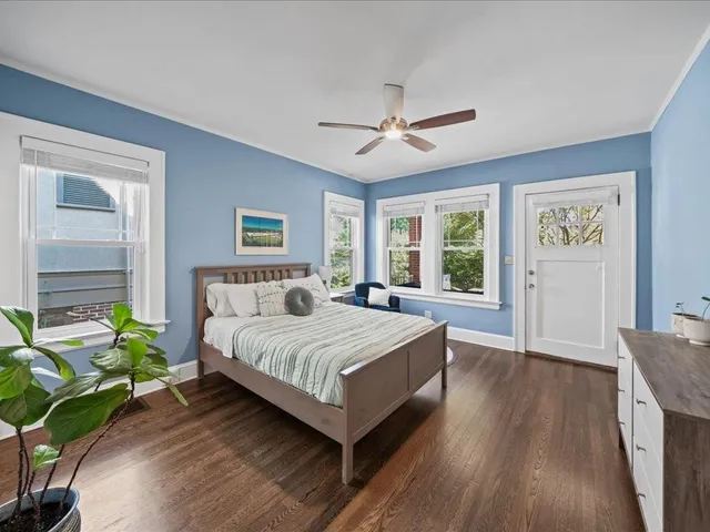 a bedroom with a bed window and wooden floor