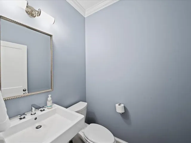 a bathroom with a sink mirror and toilet