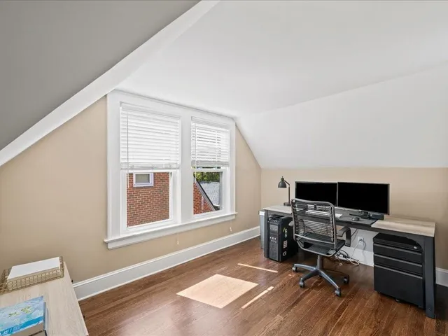 a view of a workspace with furniture and a window