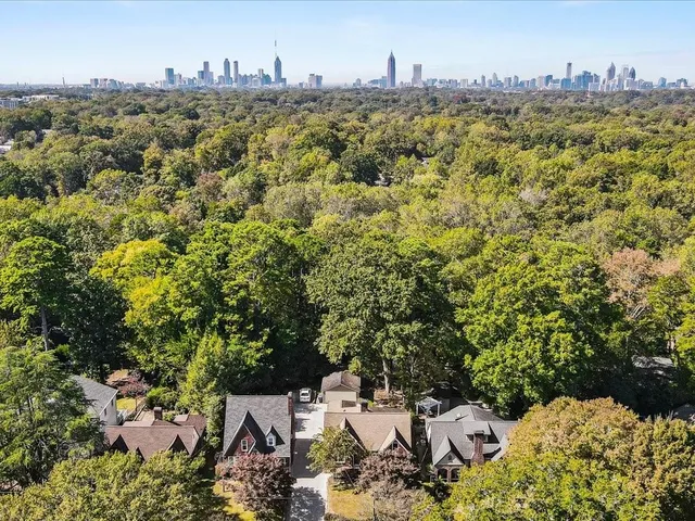 an aerial view of a house with a yard and large trees