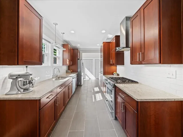 a kitchen with stainless steel appliances granite countertop a sink stove and refrigerator