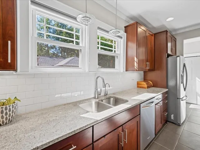 a kitchen with stainless steel appliances granite countertop a sink stove and refrigerator