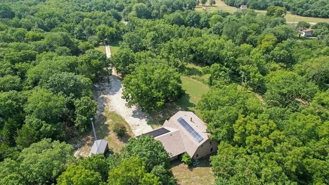 an aerial view of a house with a yard and lake view
