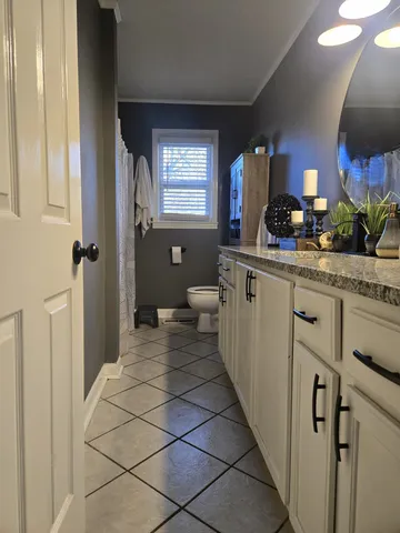 a spacious bathroom with a sink a toilet and mirror