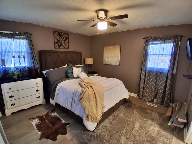 a bedroom with a bed a chandelier and a window