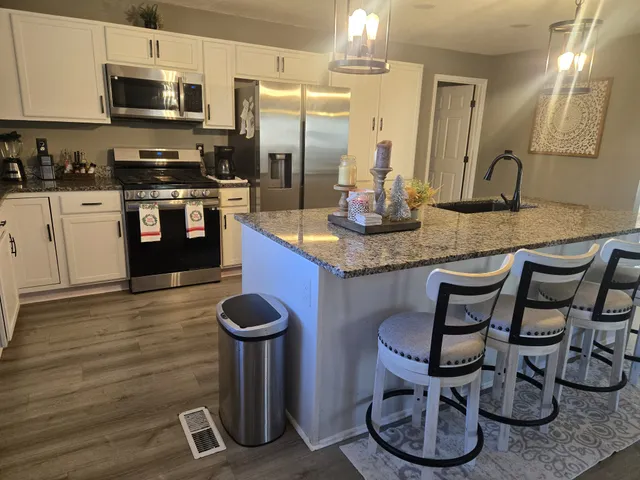 a kitchen with cabinets and chairs